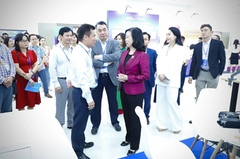 Bộ trưởng Bộ Y tế Đào Hồng Lan trò chuyện với lãnh đạo Trung tâm Thông tin Y tế Quốc gia tại khu triển lãm Nghiên cứu, ứng dụng công nghệ y tế trong chăm sóc sức khỏe diễn ra tháng 10 năm 2023.